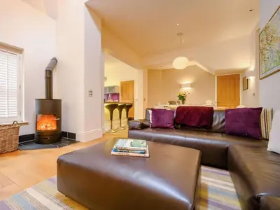 a living room with a leather couch and a fireplace at 4 Bed in Keswick oc-89258 in Keswick
