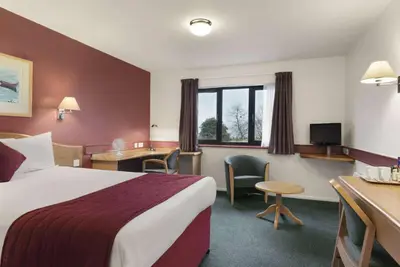 a hotel room with a bed and a desk at Days Inn Hotel Abington - Glasgow in Abington