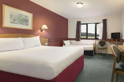 a hotel room with two beds and a desk at Days Inn Hotel Abington - Glasgow in Abington