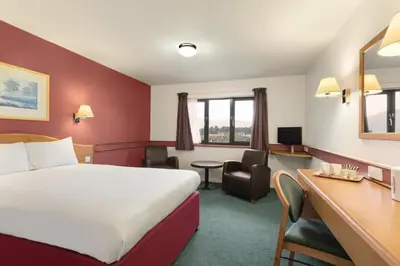 a hotel room with a bed and a desk at Days Inn Hotel Abington - Glasgow in Abington