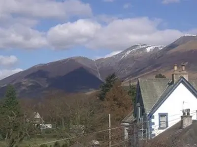a house in front of a mountain with snow at Silverdale Guesthouse in Keswick