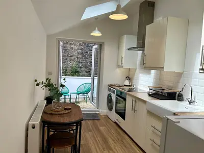 a kitchen with a small table and a sink at The Cottage, Bridge House in Laxey