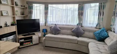 a living room with a couch and a flat screen tv at Port Carlisle Caravan near Bowness on Solway in Carlisle