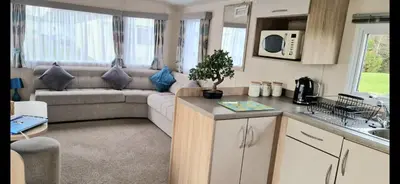 a caravan kitchen and living room with a couch at Port Carlisle Caravan near Bowness on Solway in Carlisle