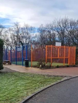 an orange fence in a park with a bench at Port Carlisle Caravan near Bowness on Solway in Carlisle