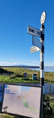 a street sign with a clock and a map at Port Carlisle Caravan near Bowness on Solway in Carlisle
