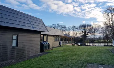 a house with a yard next to a building at Port Carlisle Caravan near Bowness on Solway in Carlisle