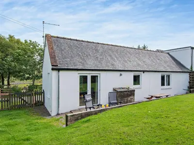 a white cottage with a grill and a grass yard at 1 Bed in Balmaclellan CA371 in Castle Douglas