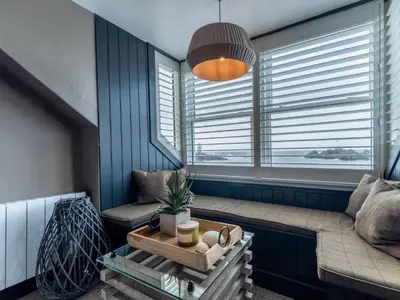 a living room with a couch and two windows at 3 Bed in Portpatrick 77308 in Portpatrick