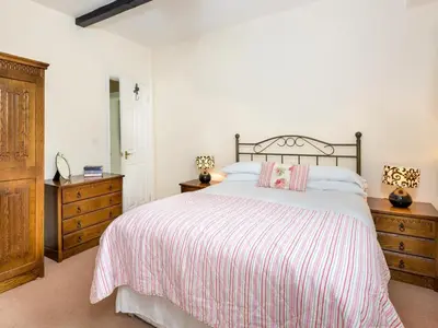 a bedroom with a large bed and a wooden dresser at 6 Bed in Workington oc-sz151 in Lamplugh