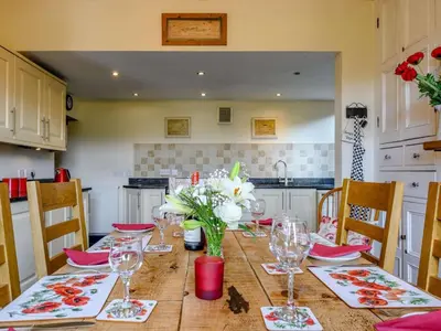 a dining room table with glasses and flowers on it at 3 Bed in Eskdale SZ072 in Santon Bridge