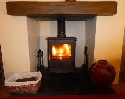 a wood burning stove in a room with a basket at 3 Bed in Keswick oc-sz446 in Portinscale