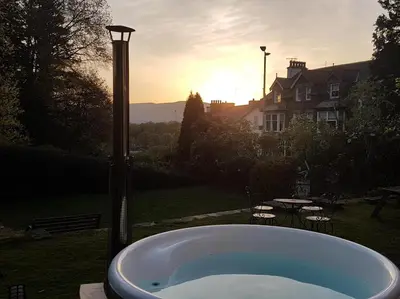a bath tub in a yard with the sunset in the background at 9 Bed in Keswick oc-sz238 in Keswick