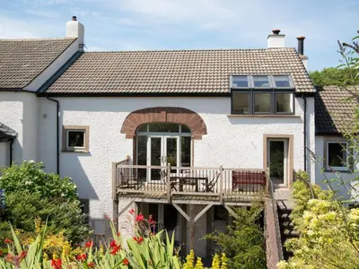 a white house with a porch and a deck at 3 Bed in Egremont oc-sz230 in Hale
