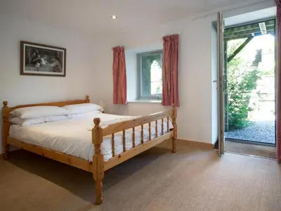 a bedroom with a wooden bed and a large window at 3 Bed in Egremont oc-sz230 in Hale