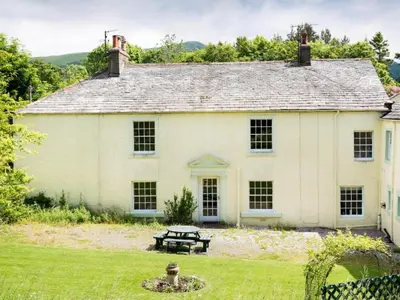 a white house with a picnic table in the yard at 6 Bed in Workington oc-sz327 in Lamplugh