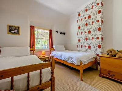 a bedroom with two beds and a wall with flowers at 3 Bed in Holmrook oc-sz414 in Santon Bridge