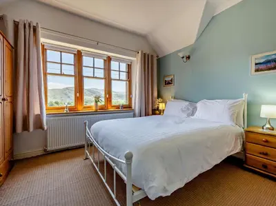 a bedroom with a large bed and a window at 3 Bed in Holmrook oc-sz414 in Santon Bridge