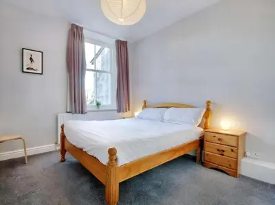 a bedroom with a wooden bed and a window at 6 Bed in Keswick oc-sz389 in Keswick