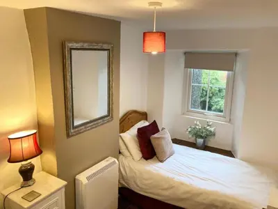 a bedroom with a bed with a mirror and a window at 2 Bed in Wasdale oc-tcsz436 in Santon Bridge