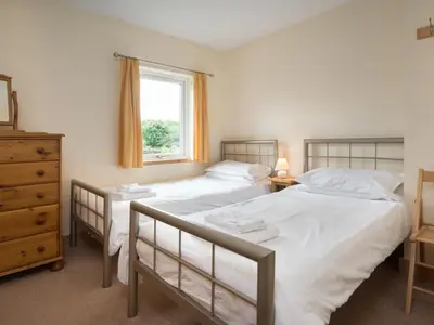 two twin beds in a bedroom with a window at 3 Bed in Egremont oc-sz058 in Hale