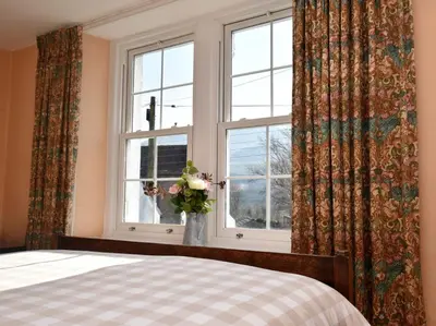a bedroom with a bed and a window with a vase of flowers at 3 Bed in Threlkeld SZ421 in Threlkeld