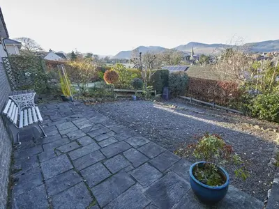 a stone patio with a bench and a plant at 2 Bed in Keswick oc-sz008 in Keswick