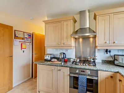 a kitchen with wooden cabinets and a stove top oven at 2 Bed in Keswick oc-sz008 in Keswick