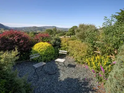 two benches sitting in the middle of a garden at 2 Bed in Threlkeld SZ082 in Threlkeld