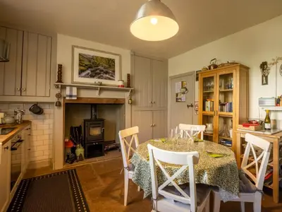 a kitchen with a table with chairs and a fireplace at 2 Bed in Threlkeld SZ082 in Threlkeld
