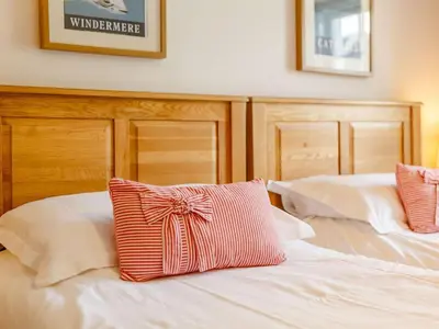 a bed with a red and white pillow on it at 2 Bed in Keswick oc-sz341 in Portinscale