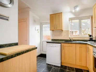 a kitchen with wooden cabinets and a white dishwasher at 1 Bed in Keswick SZ133 in Keswick