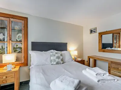 a bedroom with a bed with two tables and a mirror at 2 Bed in Ravenglass SZ409 in Ravenglass