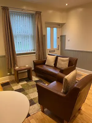 a living room with a couch and a table at Daffodil Cottage in Cockermouth