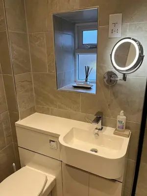a bathroom with a toilet and a sink and a mirror at Daffodil Cottage in Cockermouth