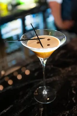 a drink in a martini glass sitting on a table at The Halston Carlisle in Carlisle