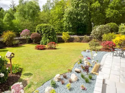 a garden with a lawn with rocks and flowers at 4 Bed in Keswick SZ267 in Keswick