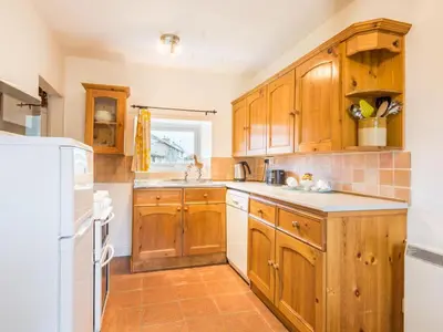 a kitchen with wooden cabinets and white appliances at 2 Bed in Keswick oc-sz415 in Bassenthwaite