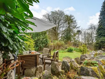 a patio with two chairs and an umbrella and rocks at 3 Bed in Keswick oc-sz065 in Applethwaite