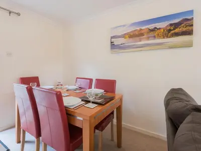 a dining room table with red chairs and a wooden table at 3 Bed in Keswick SZ547 in Keswick