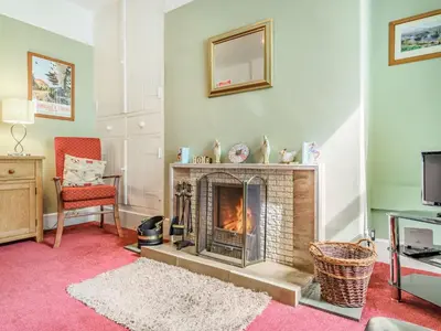 a living room with a fireplace and a chair at 3 Bed in Keswick SZ395 in Keswick