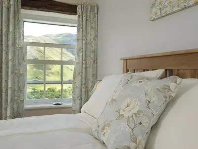 a bed with a pillow in front of a window at 3 Bed in Newlands Valley SZ075 in Borrowdale Valley