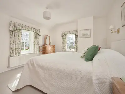 a white bedroom with a large bed and two windows at 4 Bed in Keswick oc-sz434 in Applethwaite