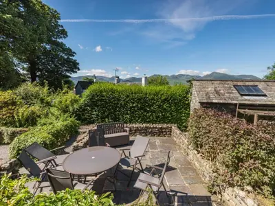 a patio with a table and chairs and a hedge at 4 Bed in Keswick oc-sz434 in Applethwaite