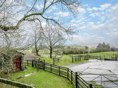 a farm with a fence and a road and trees at 2 Bed in Penrith oc-sz339 in Watermillock