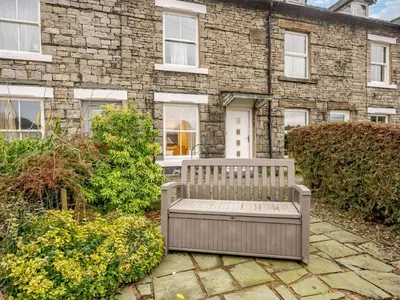 a bench sitting in front of a brick building at 2 Bed in Keswick oc-sz036 in Keswick