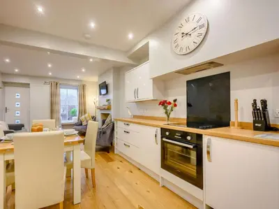a kitchen with a table and a clock on the wall at 2 Bed in Keswick oc-sz036 in Keswick
