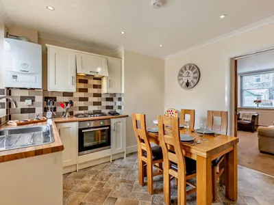 a kitchen with a wooden table and chairs in a kitchen at 2 Bed in Keswick oc-sz026 in Keswick
