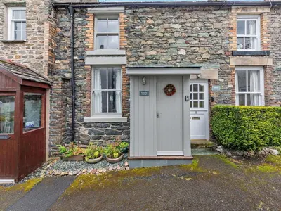 a brick house with a white door and windows at 1 Bed in Keswick oc-sz112 in Keswick