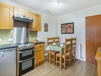 a kitchen with a stove and a table with chairs at 2 Bed in Keswick SZ462 in Keswick
